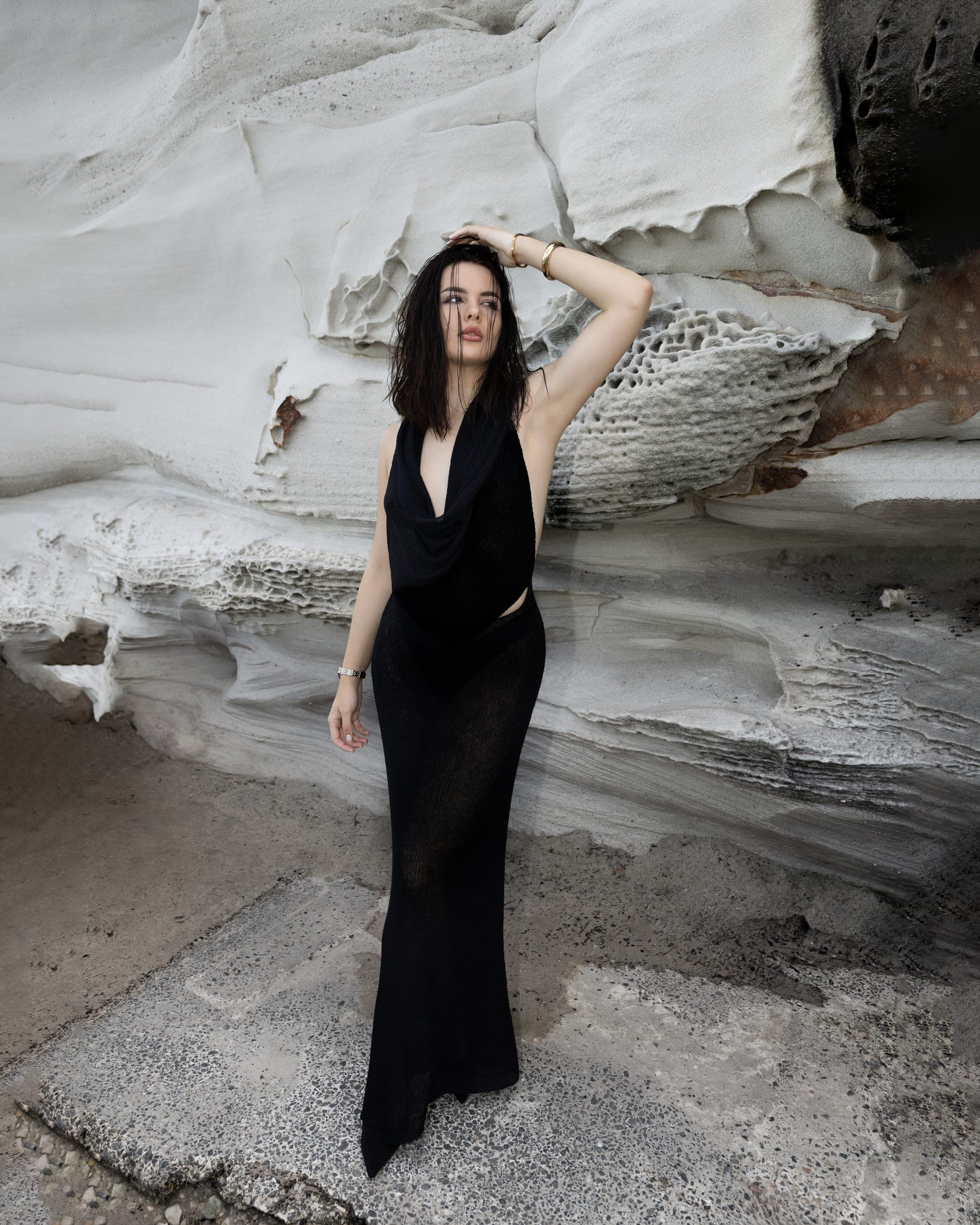 Fashion model in a black backless dress against white sandstone rock formations, Sydney editorial photography